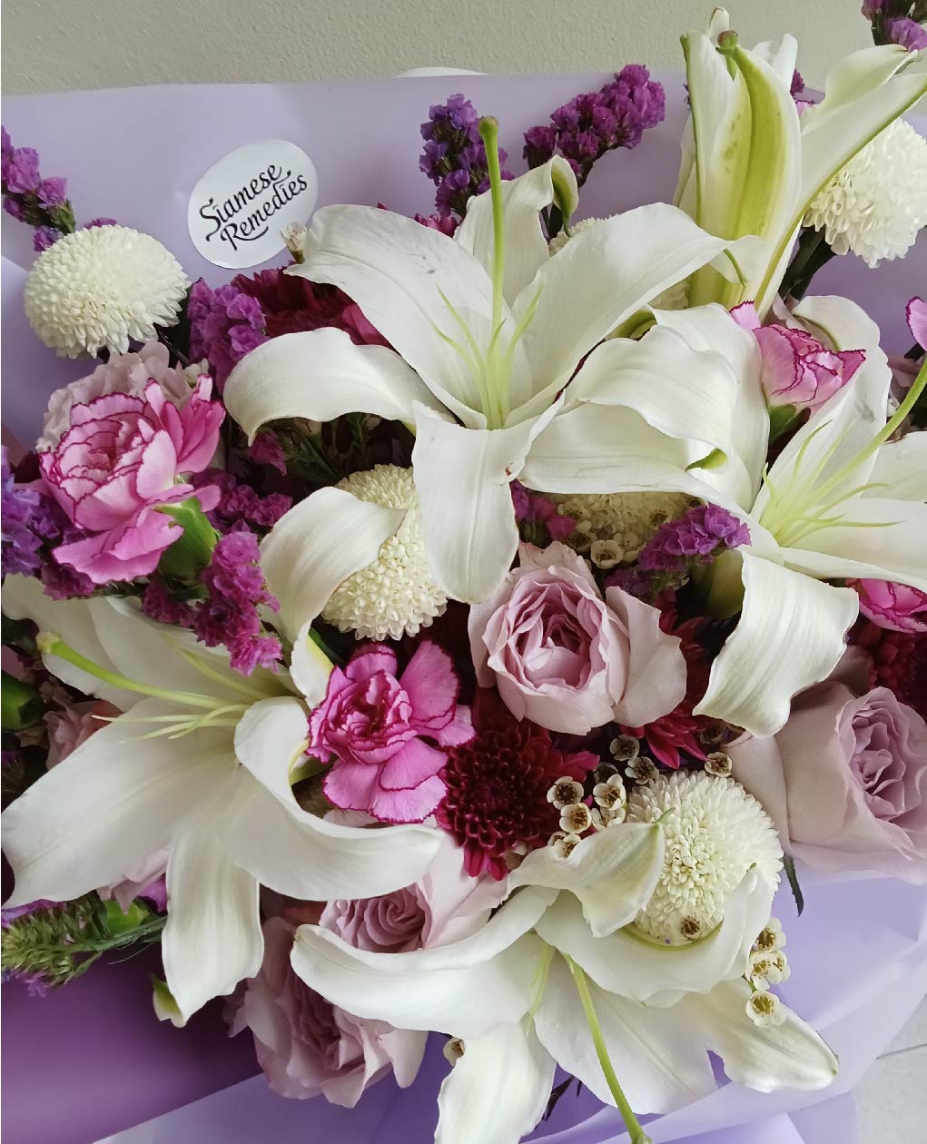 Elegant Enchanted Lilies bouquet with cream lilies, purple roses, pink carnations, and white chrysanthemums, perfect for Phuket flower gifts.