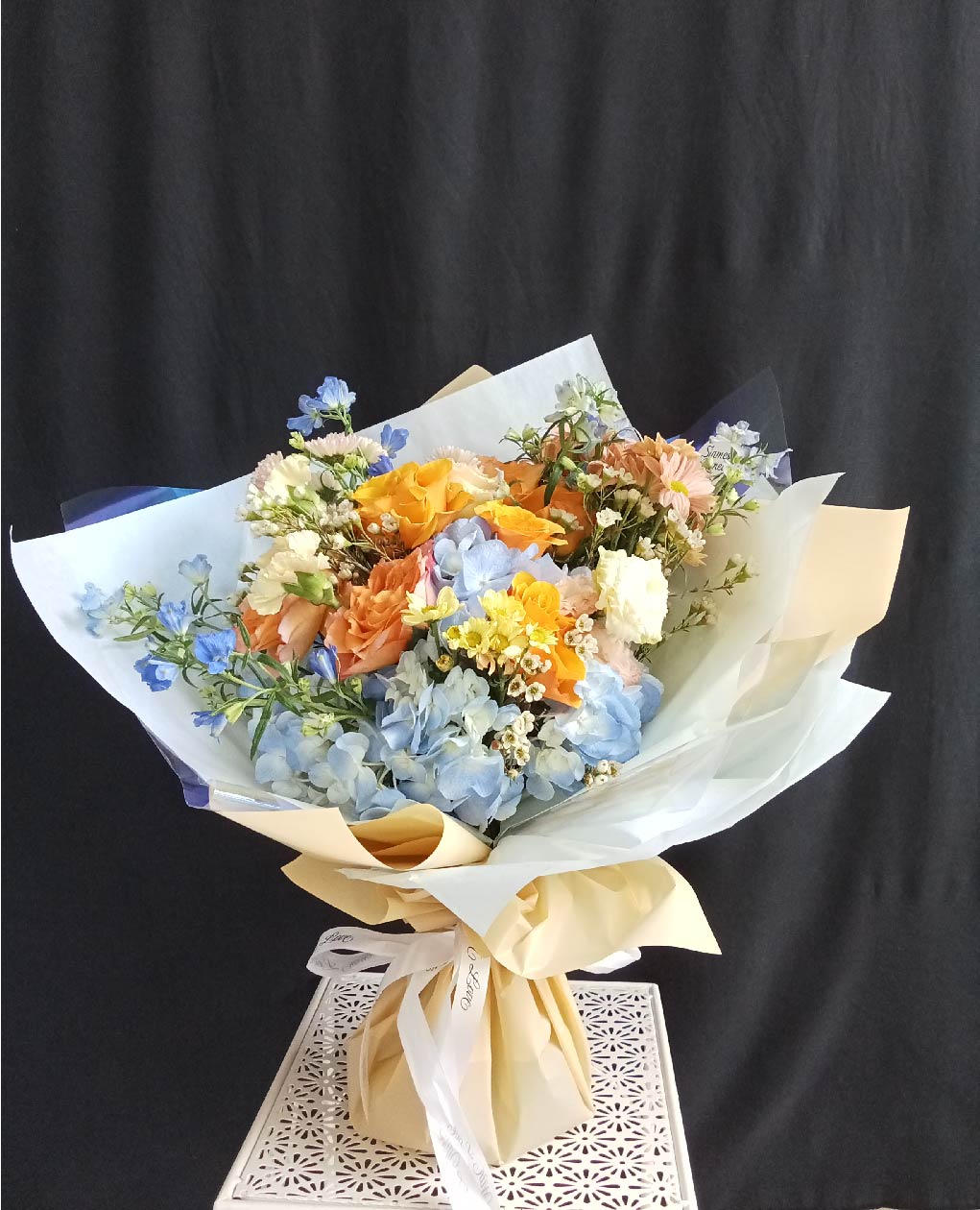 Pastel Dreams bouquet featuring blue hydrangeas, peach roses, and white carnations, perfect for special occasions in Phuket.