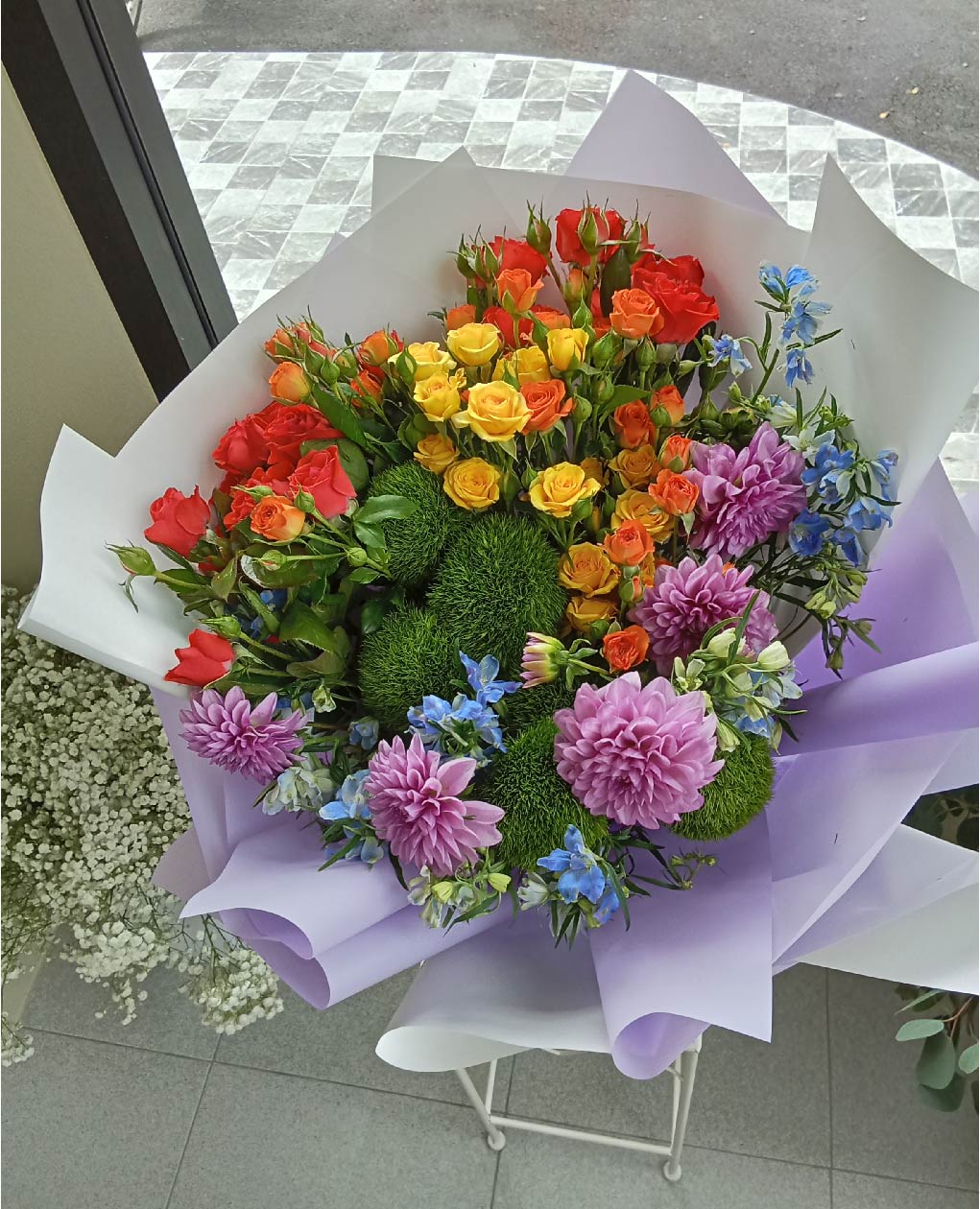 Vibrant Pride Bouquet with roses, dahlias, delphiniums, and greenery. A beautiful arrangement of Phuket flowers for any celebration.